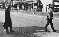 Een Nederlandse onderhandelaar (met de witte vlag) geeft zich op 14 mei 1940 over in de Van der Takstraat in Rotterdam. De Duitsers hebben op dat moment het Noordereiland bezet. © Bundesarchiv
